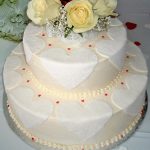 photo of a two tier cake with roses on top