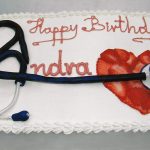 photo of a cake with heart made with strawberries and a stethoscope