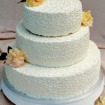 photo of a three tier cake with yellow roses